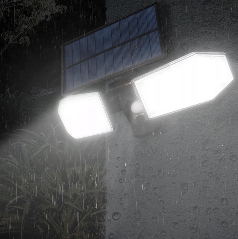 Naświetlacz solarny LED 15W z czujnikiem ruchu, zasilany energią słoneczną, o jasności 450lm i temperaturze barwowej 5500K. Montowany na ścianie, z dwoma ruchomymi panelami świetlnymi, widoczny w deszczowym otoczeniu.