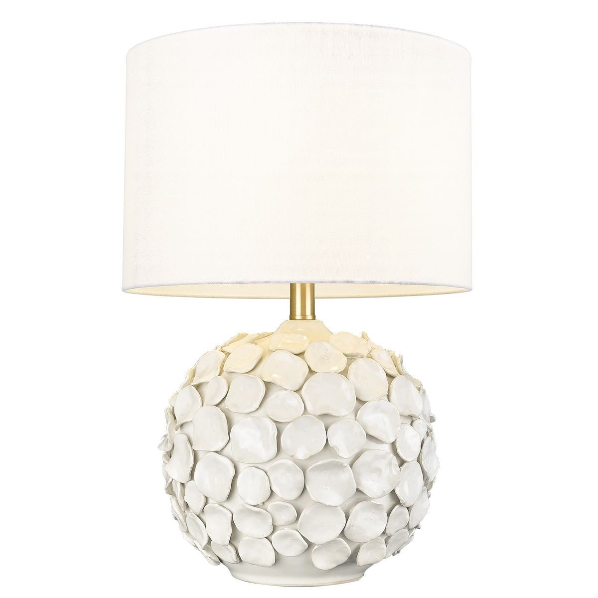 Lampa stołowa Koto z białym kloszem i podstawą z ceramicznych, zaokrąglonych elementów. Ułożona na stole, z metalowym stelażem w kolorze złotym. Klosz zapewnia miękkie światło, a podstawa ma teksturę przypominającą kamieniste wykończenie.