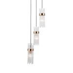 Lampa wisząca Taraso z trzema źródłami światła E14. Czarna podstawa z metalowymi złotymi akcentami oraz przezroczyste, szklane elementy w formie prętów. Ujęcie z przodu, zwisająca, w nowoczesnym stylu.