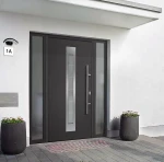 Czarny kinkiet elewacyjny Bella LED z czujnikiem ruchu, zamontowany obok drzwi wejściowych. Kinkiet ma nowoczesny design i jest umieszczony na białej ścianie, w otoczeniu donic z kwiatami.