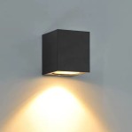 Kinkiet elewacyjny ogrodowy Lida w kolorze czarnym, o kwadratowym kształcie. Zamontowany na ścianie, emitujący światło w dół. Wbudowany gniazdo GU10, wykończenie matowe. Tło jednolite, jasne, podkreślające lampę.