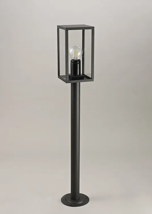 Lampa stojąca ogrodowa Malmo H68 w kolorze grafitowym, z prostokątną kloszem osłaniającym żarówkę. Produkt ma stalowy słup i podstawę mocującą, prezentowany w pozycji stojącej na jednolitym tle.