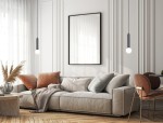 Lampa wisząca Filano 1xG9 w kolorze czarnym, zawieszona w nowoczesnym wnętrzu. Główna część lampy ma cylindryczny kształt, z białą żarówką na końcu. Otoczenie to jasny pokój z sofą, poduszkami i dekoracjami roślinnymi.