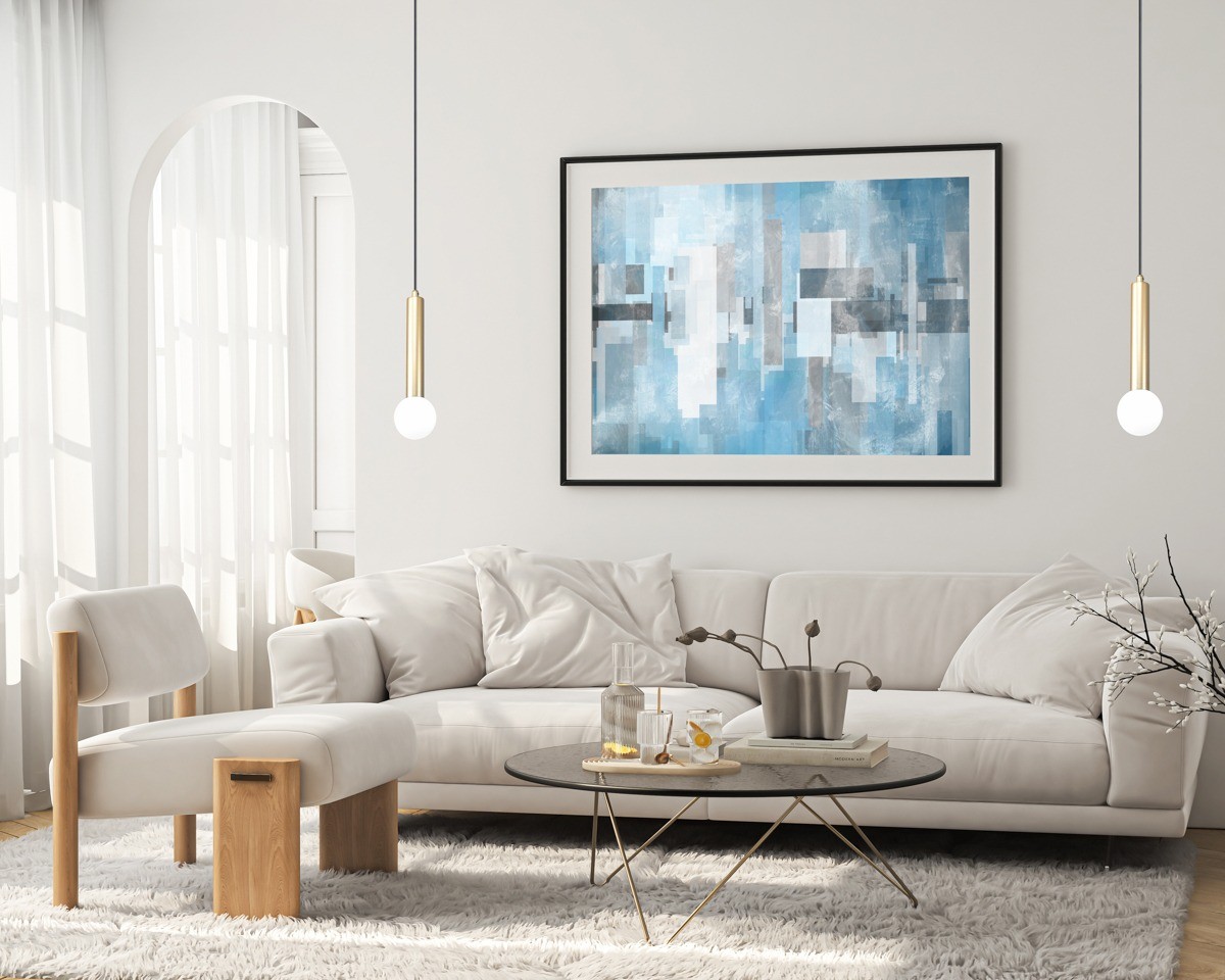 Złota lampa wisząca Filano 1xG9 z minimalistycznym, cylindrycznym kloszem i okrągłą żarówką, zawieszona w jasnym wnętrzu z kanapą i stołem kawowym. Tło stanowi ściana z obrazem w odcieniach błękitu i szarości.