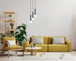 Lampa wisząca Filano 3xG9 w kolorze czarnym z trzema okrągłymi kloszami, zawieszona na długich przewodach. Ujęcie frontalne, w tle żółta sofa i drewniana półka z roślinami. Tło jasne, minimalistyczne.