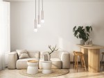 Lampa wisząca Filano 3xG9 w kolorze kawowym z trzema okrągłymi kloszami, zawieszona na czarnych przewodach. Produkt umieszczony w nowoczesnym wnętrzu z jasnym narożnikiem, drewnianym stołem oraz rośliną na tle stonowanej ściany.