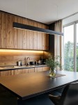 Lampa wisząca Linia Slim w kolorze czarnym, z jedną diodą LED o mocy 30W i temperaturze barwowej 4000K, zawieszona nad drewnianym blatem w nowoczesnej kuchni, z widocznymi elementami wyposażenia i rośliną w wazonie.