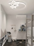 Lampa sufitowa w kształcie gwiazdek z pilotem, LED 60W CCT, biała. Wisi na suficie, otoczona okręgiem. W tle widać pokój dziecięcy z drewnianym łóżkiem piętrowym, półkami oraz zabawkami na podłodze.