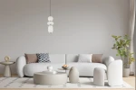 Lampa wisząca Nico 3xLED 15W w kolorze złotym i białym, zawieszona nad jasnoszarym sofą. Składa się z trzech okrągłych kloszy o gładkiej teksturze, z metalowymi detalami. Tło w neutralnym odcieniu, w aranżacji nowoczesnego wnętrza.