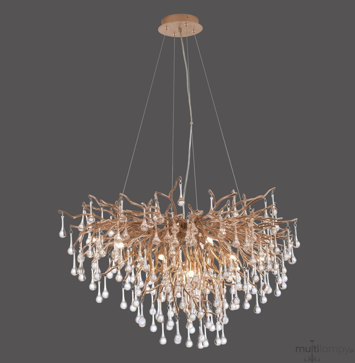 Lampa wisząca Icicle w postarzanym mosiądzu, z dziesięcioma źródłami światła G9. Posiada organiczny kształt z dekoracyjnymi elementami przypominającymi gałęzie, z licznymi wiszącymi kryształowymi kroplami. Zawieszona na cienkich linkach.