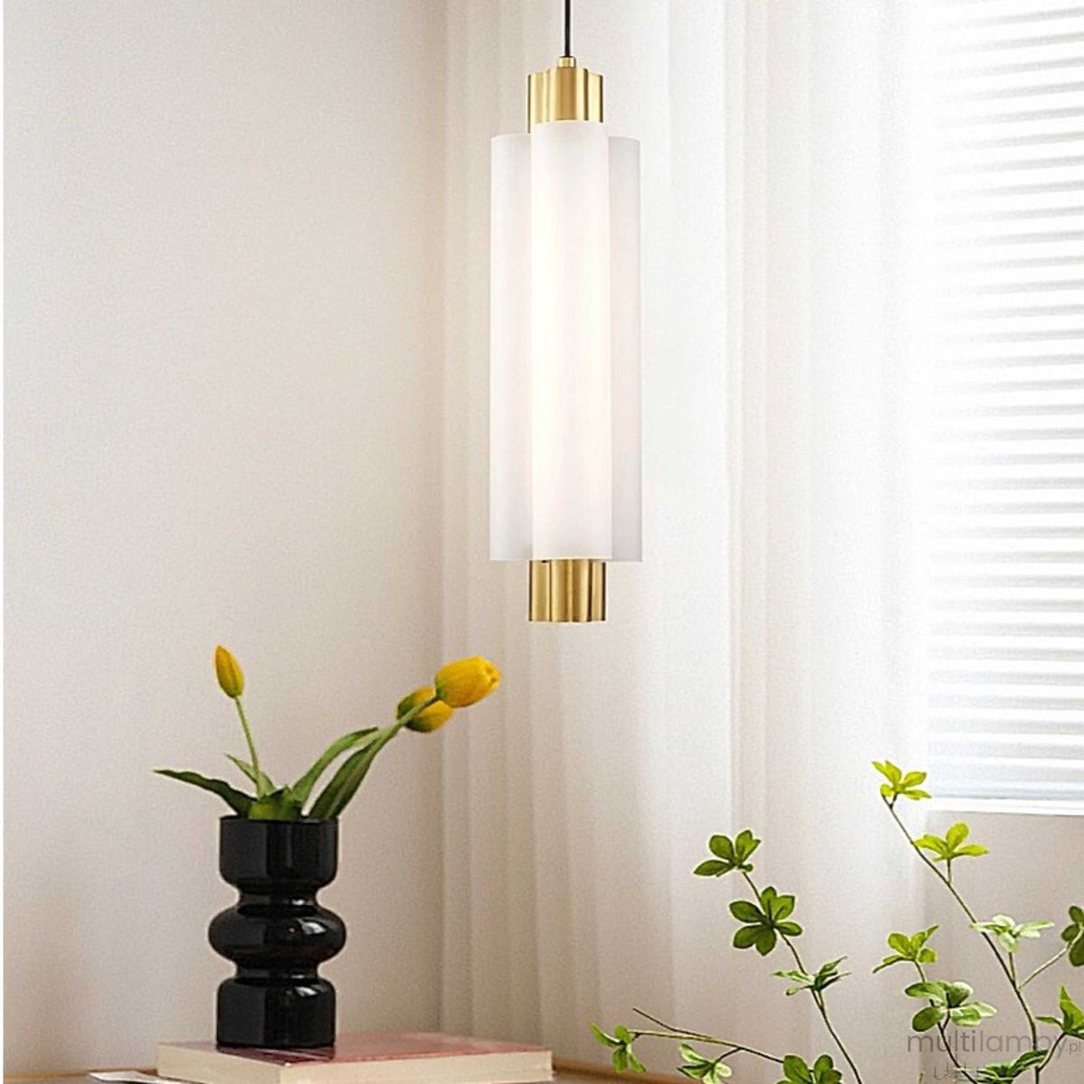 Lampa wisząca LED Osmo 9W 3000K z mosiężnymi detalami i matowym kloszem, zawieszona na czarnym przewodzie. W tle widoczne rośliny doniczkowe oraz jasne zasłony.