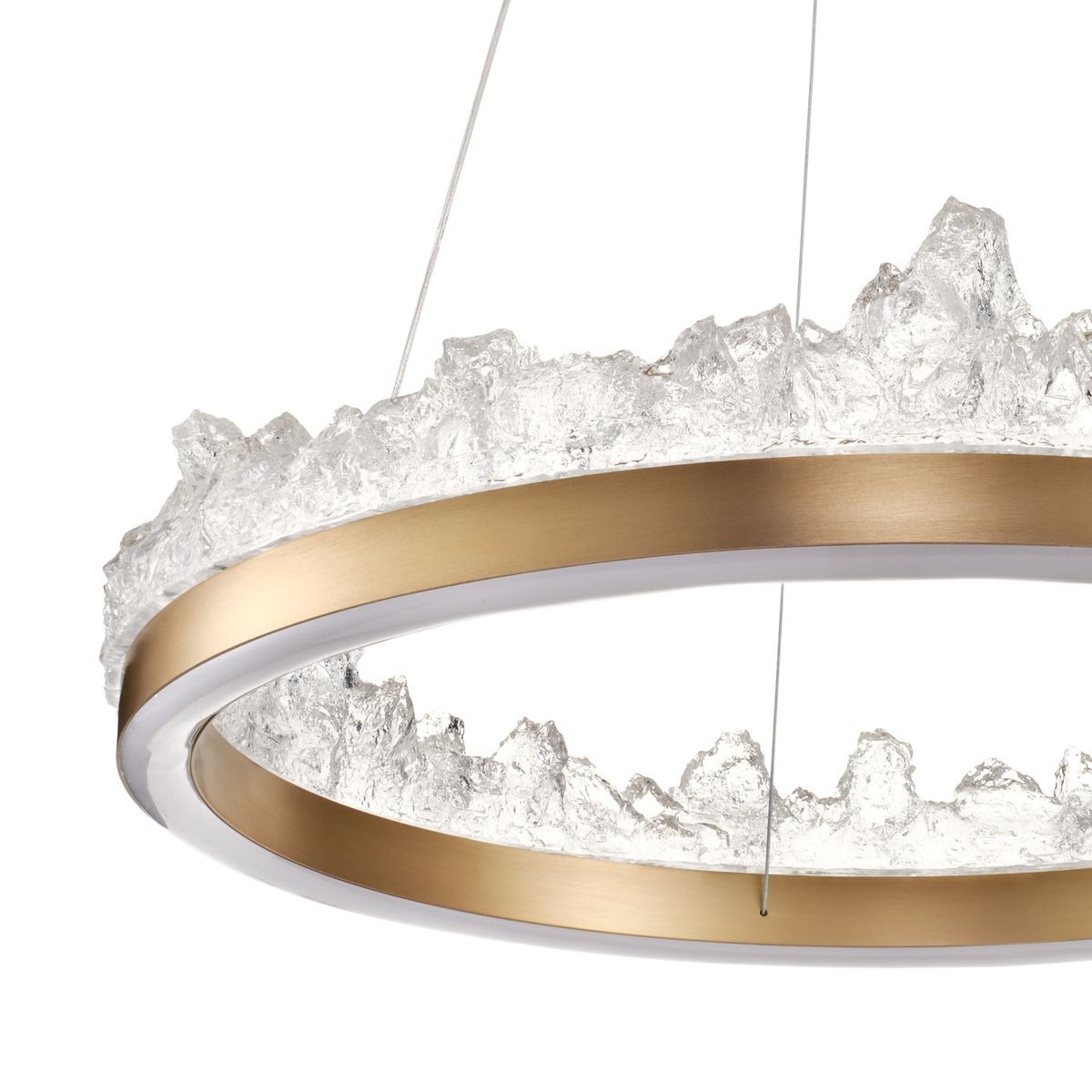 Lampa wisząca LED Montana 26W 3000K w złotym kolorze z przezroczystym, teksturowanym kloszem. Okrągła forma z wyraźnym, nieregularnym brzegiem. Zawieszona na cienkich linkach, idealna do nowoczesnych wnętrz.