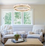 Lampa wisząca LED Montana o mocy 26W, kolor złoty, z okrągłym kształtem i dekoracyjnym, teksturowanym kloszem. Zawieszona w salonie nad niskim stolikiem, w jasnym otoczeniu z oknami, otaczająca przestrzeń naturalnym światłem.