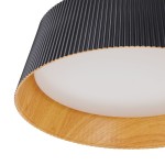 Lampa wisząca LED Frill 21W w kolorze czarnym, z cylindrycznym kloszem z teksturowanego materiału i drewnianą podstawą. W centralnej części znajduje się matowa, biała oprawa, emitująca światło o temperaturze 3000K.