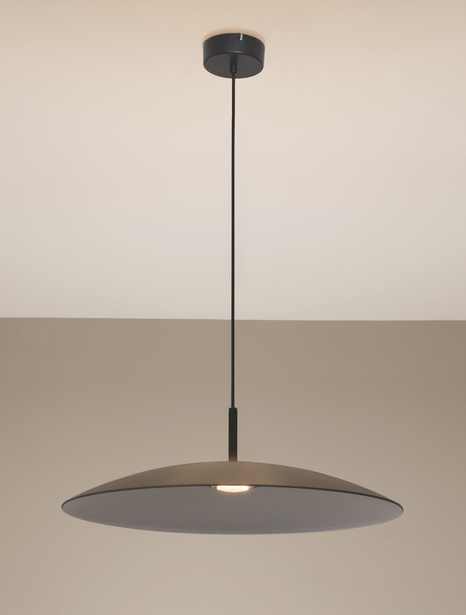 Lampa wisząca Peca w kolorze czarnym z szarym kloszem, zawieszona na cienkim, czarnym przewodzie. Klosz ma okrągły, płaski kształt z centralnym źródłem światła LED 17W. Tło w jasnym odcieniu, podkreślającym elegancki design.