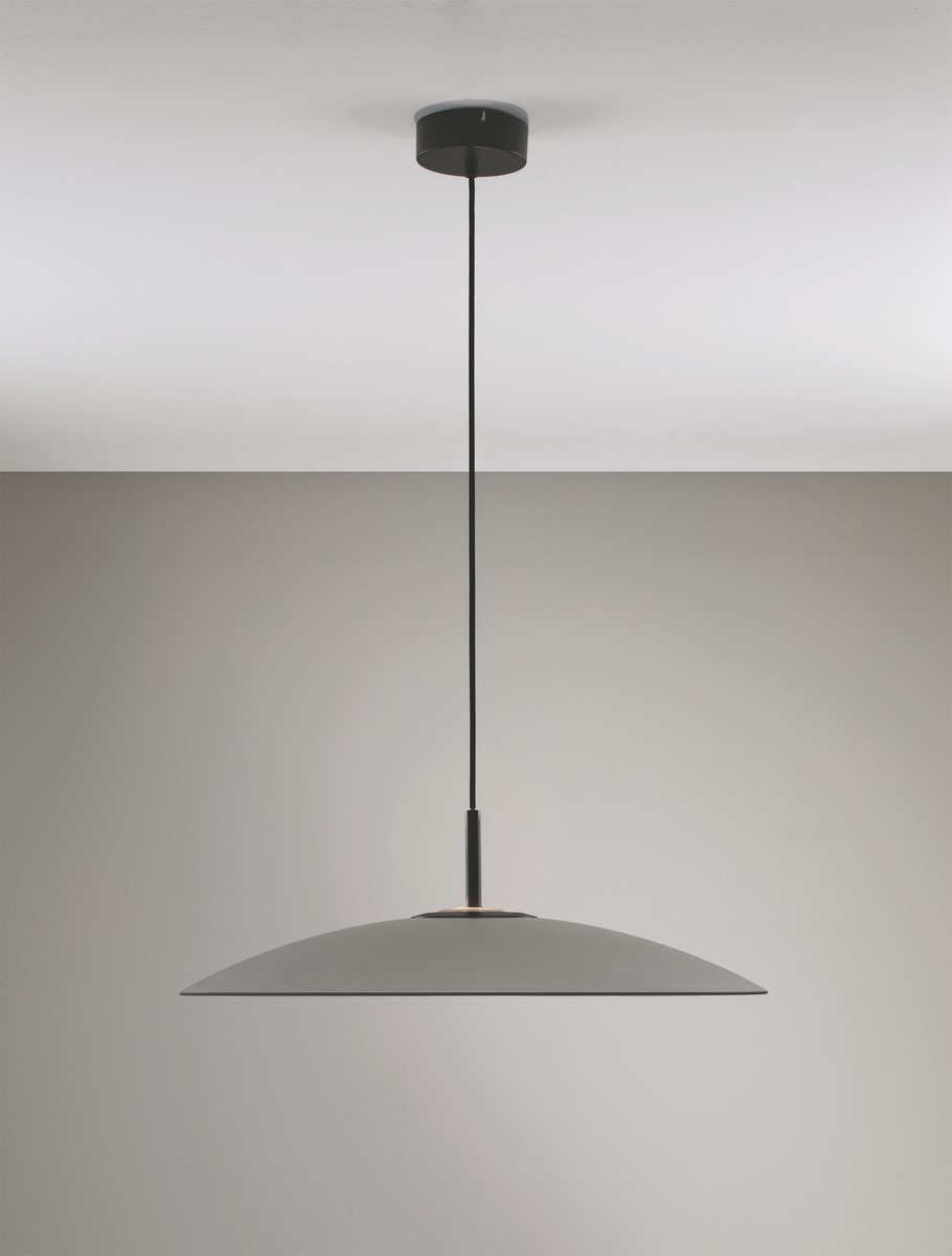 Lampa wisząca Peca w kolorze czarnym z szarym kloszem, z pojedynczym źródłem światła LED 17W. Zawieszona na cienkim przewodzie, z okrągłym mocowaniem sufitowym. Prosta, minimalistyczna forma. Tło w odcieniach szarości.