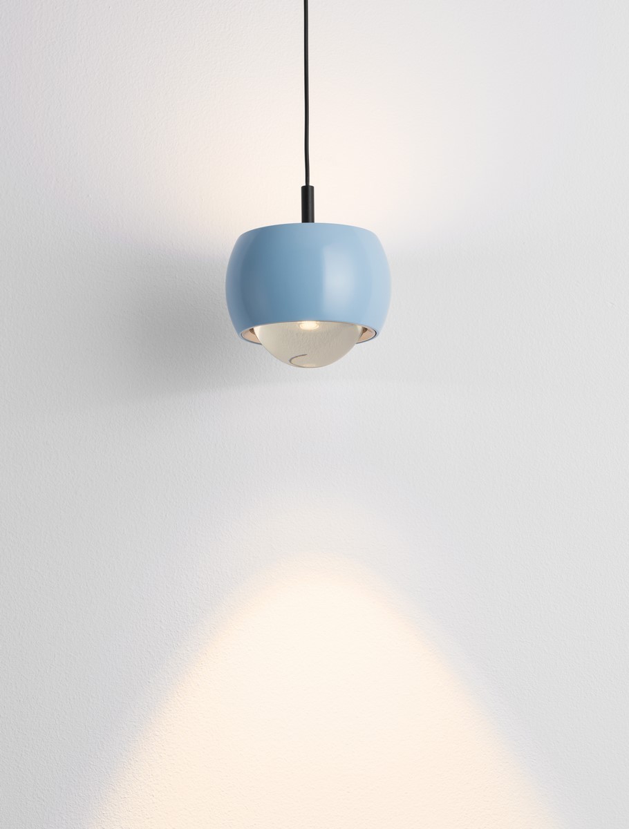 Lampa wisząca Lima w kolorze błękitnym z 1xLED 13W. Okrągła, ceramiczna obudowa z matowym wykończeniem, zawieszona na czarnym przewodzie. Emituje ciepłe światło, tworząc delikatny cień na ścianie.