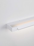 Kinkiet Justo w kolorze białym, wykonany z metalu. Z prostokątnym, płaskim designem. Zintegrowane źródło światła LED 17W, emitujące ciepłe światło z górnej krawędzi. Montowany na ścianie, widoczny z boku. Tło jasne, minimalistyczne.