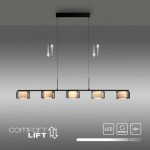 Lampa wisząca Rika z pięcioma źródłami LED 42W w czarnym dymionym kolorze, zawieszona na prostokątnej podsufitce. Klosze w formie sześcianów z transparentnym wykończeniem, regulowana wysokość zawieszenia. Nowoczesny design, idealna do jadalni lub salonu.