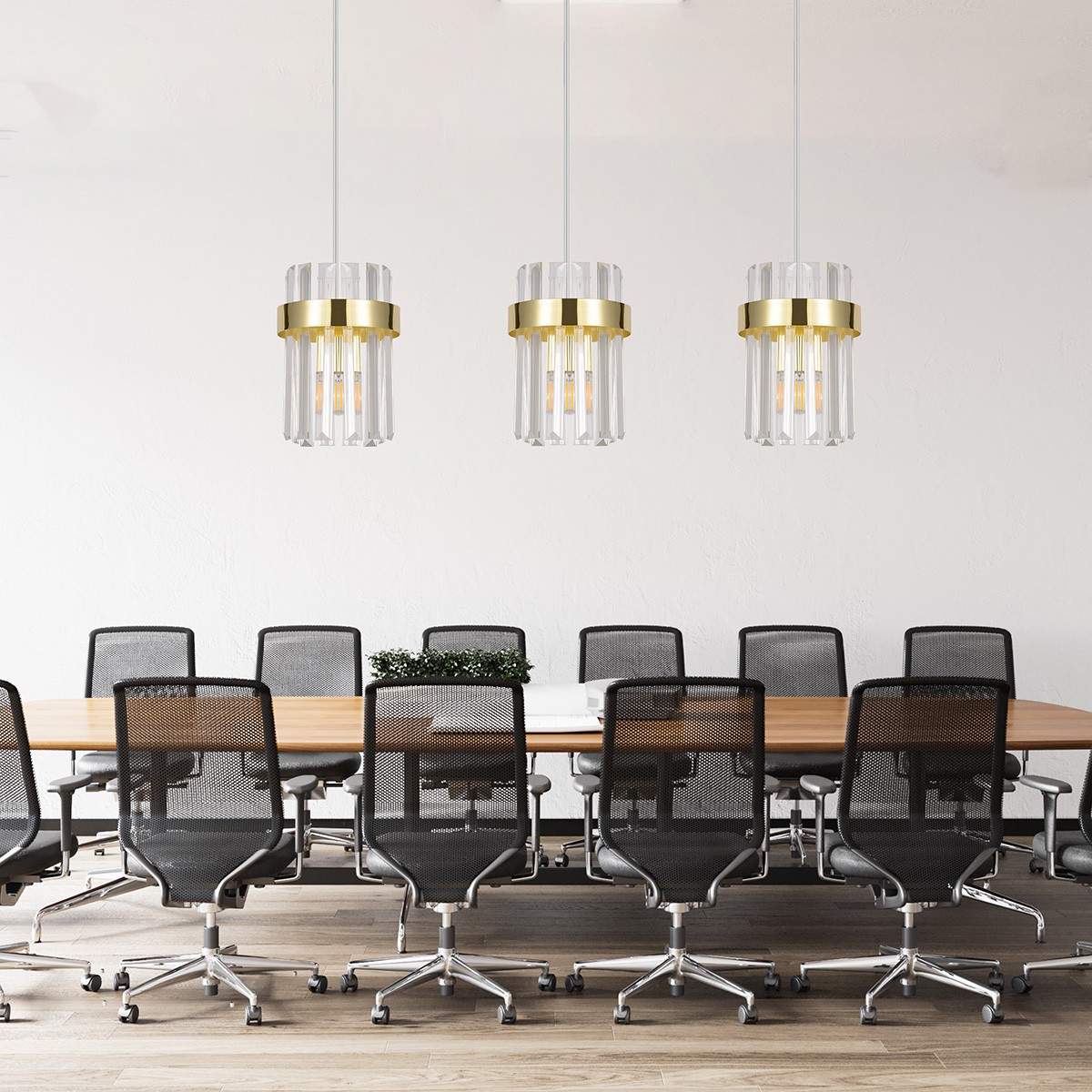 Lampa wisząca Vetro LP-2910/3L GD z trzema źródłami światła E14. Szklane klosze z przezroczystymi prętami i złotymi detalami. Zawieszona nad stołem w nowoczesnej przestrzeni biurowej, na jasnym tle z drewnianym blatem i czarnymi krzesłami.