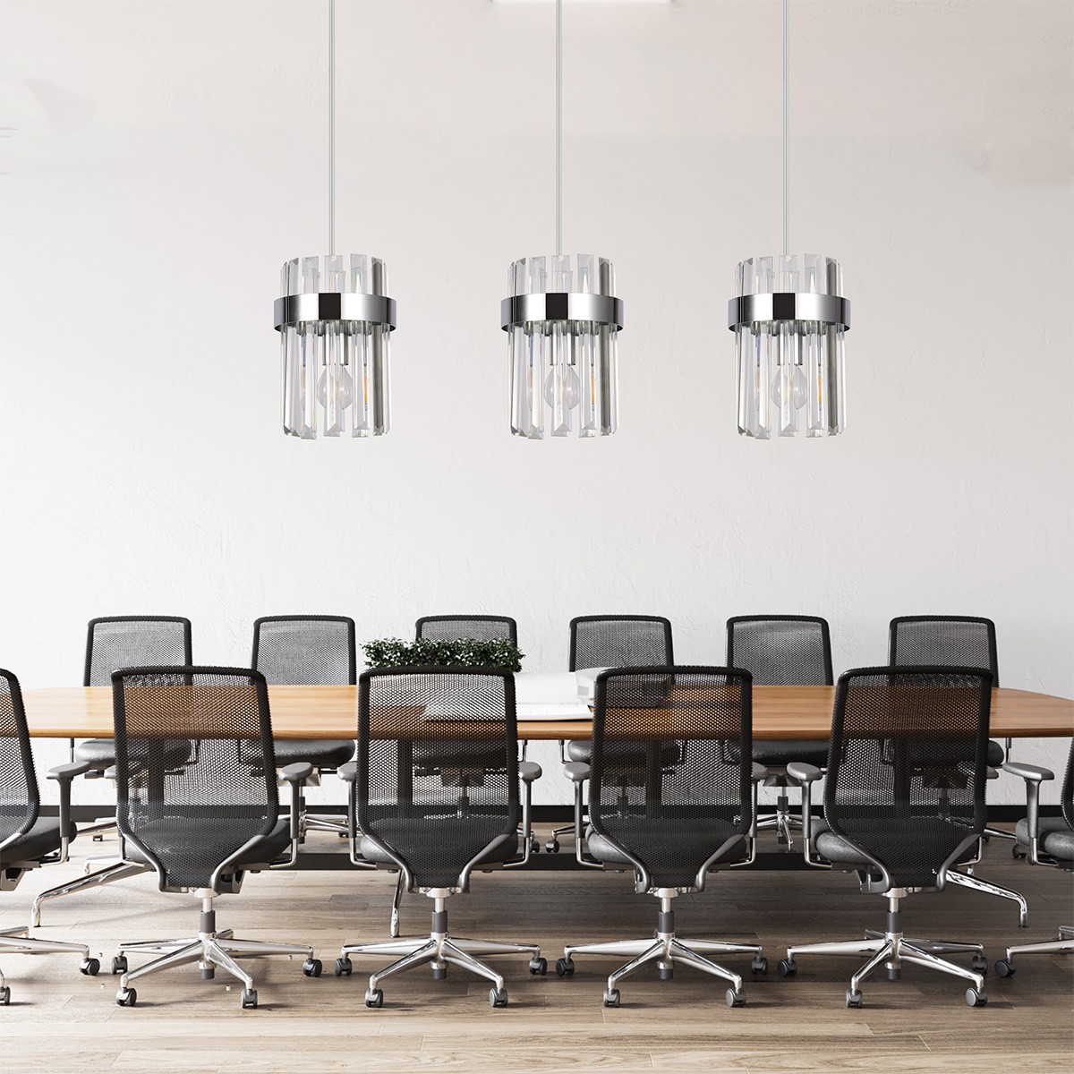 Lampa wisząca Vetro 3xE14 w chromowanej obudowie z przezroczystymi kloszami, zawieszona na białych linkach. Znajduje się nad drewnianym stołem konferencyjnym w nowoczesnym biurze, otoczona czarnymi krzesłami obrotowymi.