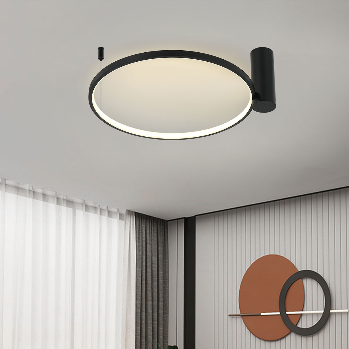 Czarna lampa sufitowa LED Ring D60 o mocy 35W z okrągłym, matowym kloszem. Ujęcie z dołu, lampę zamontowano na suficie. W tle widoczne zasłony i dekoracyjne elementy ścienne w stonowanej kolorystyce.