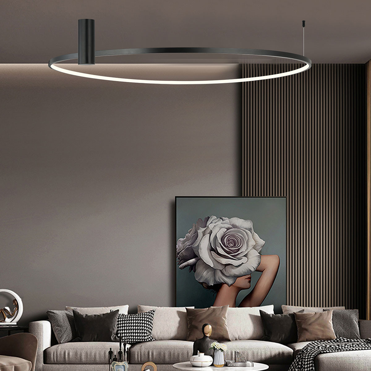 Lampa sufitowa LED Ring D90 o mocy 50W w kolorze czarnym, w kształcie okręgu, zawieszona na cienkim przewodzie. Emituje ciepłe światło, idealna do nowoczesnych wnętrz. Tło stanowi stylowa aranżacja pokoju z sofą i obrazem.
