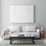 Lampa wisząca LED Mirror D60 o mocy 35W w złotym kolorze, zawieszona w centralnej części pomieszczenia, nad białą sofą. Tło stanowi jasna ściana z dużym, białym obrazem. Widać także stół kawowy z białymi naczyniami i drewnianą dekorację.