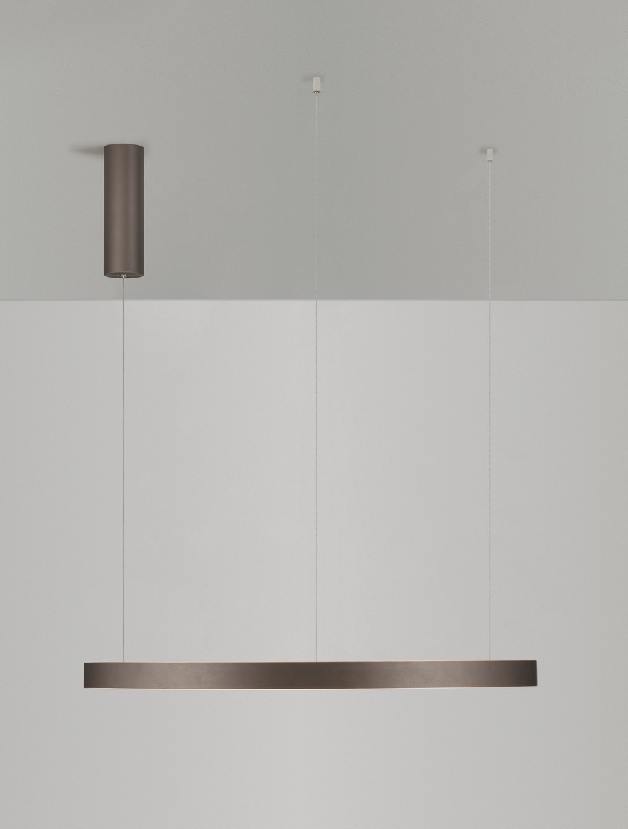 Lampa wisząca Bari D80 w kolorze brązowym z jedną diodą LED 77W. Posiada minimalistyczny, okrągły kształt, zawieszona na cienkich linkach. Górna część z cylindrycznym mocowaniem, umieszczona na jasnym tle.