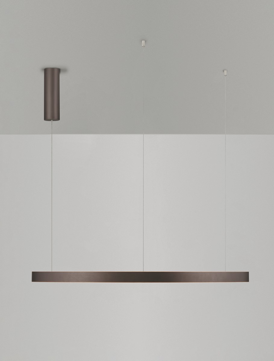 Brązowa lampa wisząca Bari D98 z jednym źródłem światła LED, o prostokątnym kształcie. Ujęcie frontalne, zawieszona na cienkich żyłkach z cylindrycznym mocowaniem sufitowym. Tło w odcieniach szarości, minimalistyczne.