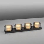 Lampa sufitowa Rika z czterema źródłami LED 26W, w czarnym dymionym kolorze. Okrągłe klosze z przezroczystego szkła na prostokątnej podstawie. Ujęcie frontalne, produkt leży na stole, tło w odcieniach szarości.