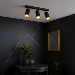 Lampa sufitowa Mica z trzema reflektorami GU10 w kolorze czarnym z złotymi detalami. Zamontowana na suficie, z jasnym światłem skierowanym w dół. W tle widoczna ciemna ściana z marmurowym wzorem oraz rośliny w doniczkach na stoliku.