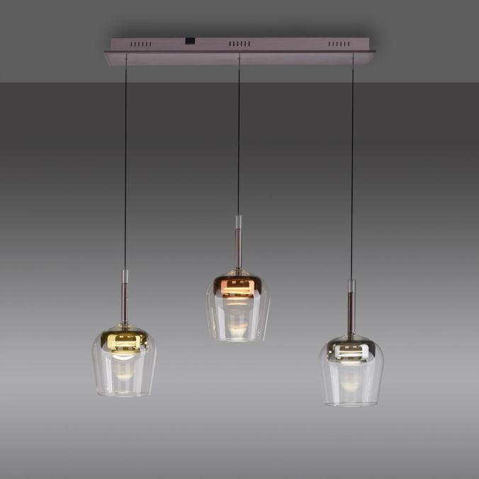 Lampa wisząca Q-kon z pilotem, trzy klosze w różnych kolorach: złoty, mosiężny i przezroczysty. Klosze mają okrągły kształt, zawieszone na długich linkach, montowane na prostokątnej, metalowej podstawie. Wbudowane 3xLED 27W CCT.