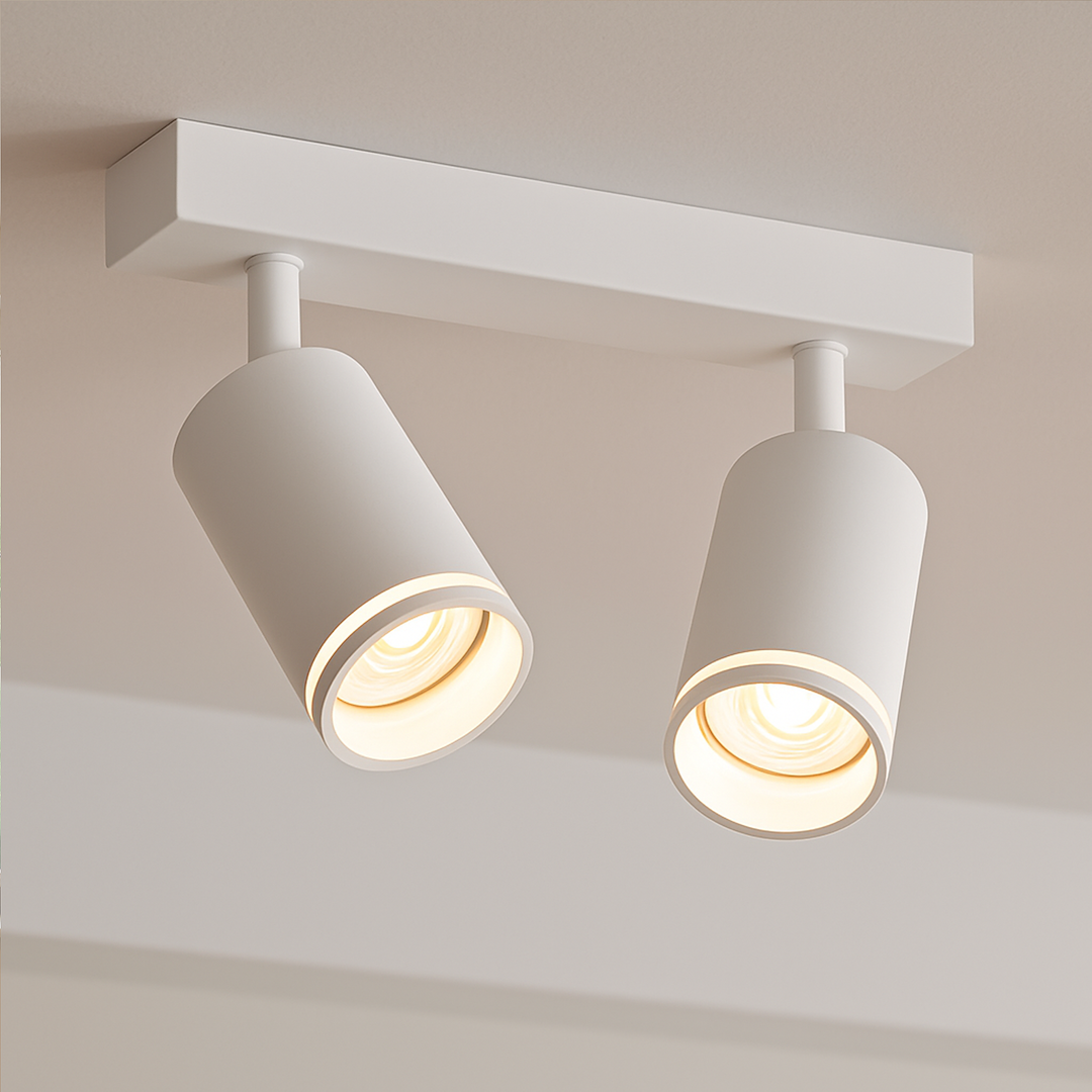 Lampa sufitowa Pipe Ring w kolorze białym z dwoma reflektorami GU10. Reflektory mają okrągły kształt i są zamontowane na prostokątnej podstawie. Ujęcie z dołu, ukazujące detale strukturalne i źródła światła.