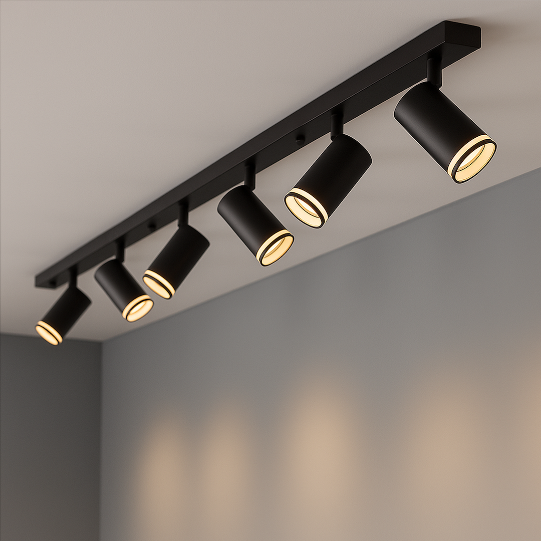 Lampa sufitowa Pipe Ring z sześcioma spotami GU10 w kolorze czarnym, zamontowana na prostokątnej listwie. Kąt ujęcia z góry, widoczne cylindryczne klosze z jasnym wnętrzem, montowana na szarym tle.