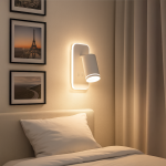 Biały kinkiet Pipe Ring z lampą LED 6W, montowany na ścianie, w kształcie cylindrycznym. Oświetlenie skierowane w dół, zamontowane obok łóżka, z widocznymi zdjęciami na ścianie w tle oraz zasłonami.