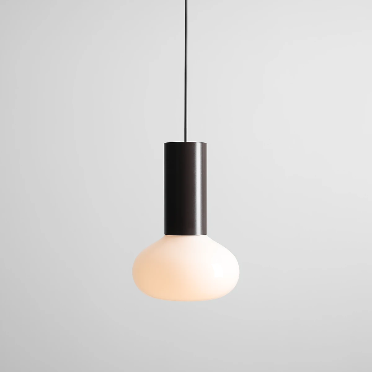 Lampa wisząca Flo Mokka D19 z czarnym cylindrycznym uchwytem i kulistym kloszem w kolorze mlecznym. Zawieszona na cienkim kablu, prezentuje nowoczesny design. Idealna do aranżacji wnętrz. Wymiary: średnica klosza D19 cm.