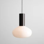 Lampa wisząca Flo Mokka D26 z oprawą w kolorze czarnym i szklanym kloszem w odcieniu mlecznym. Kształt klosza przypomina kroplę, zawieszona na cienkim przewodzie, idealna do nowoczesnych wnętrz.