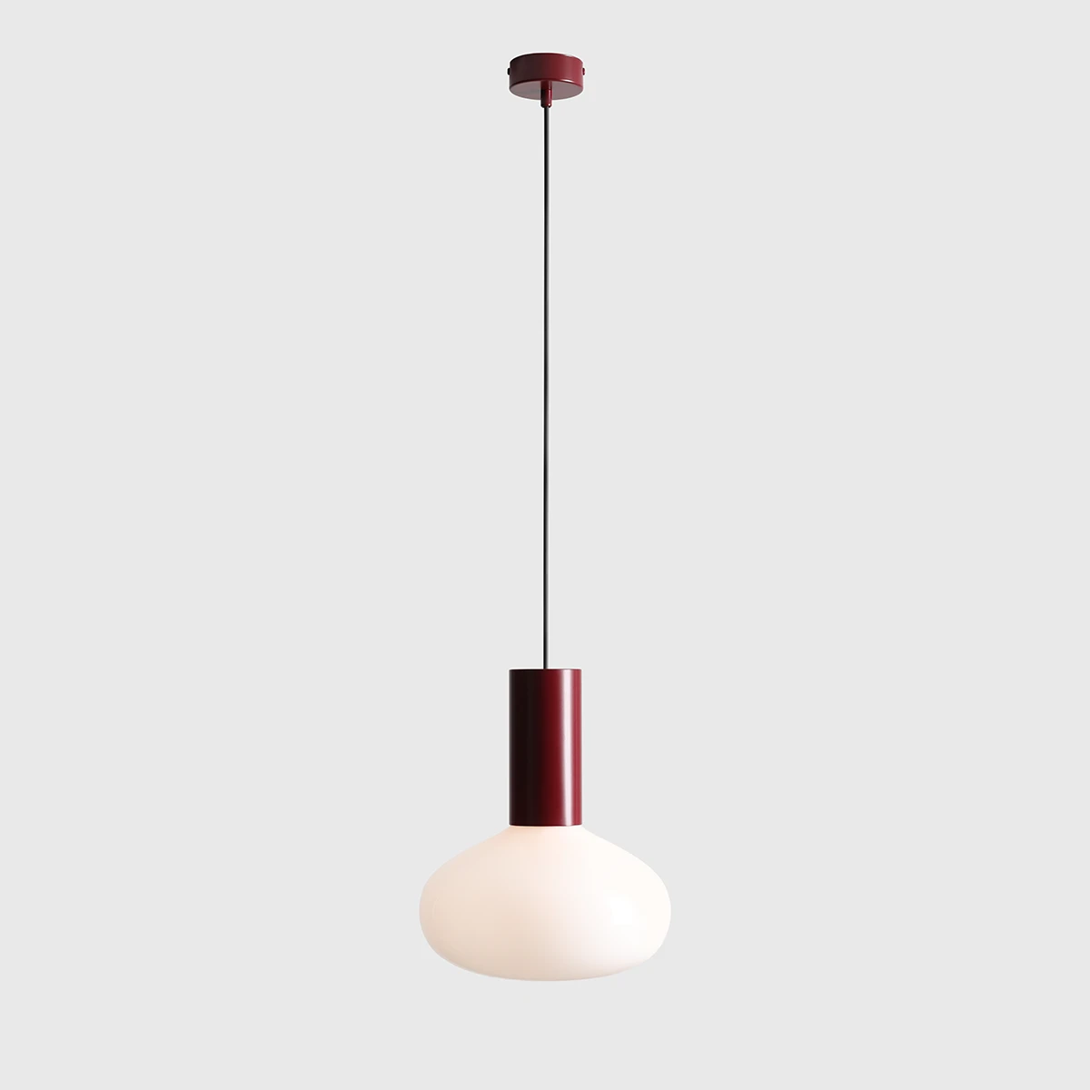 Lampa wisząca Flo Ruby D26 z jednym źródłem światła E14. Posiada okrągły, mlecznobiały klosz oraz cylindryczny, ciemnoczerwony uchwyt. Zawieszona na cienkim, czarnym przewodzie, idealna do nowoczesnych wnętrz.