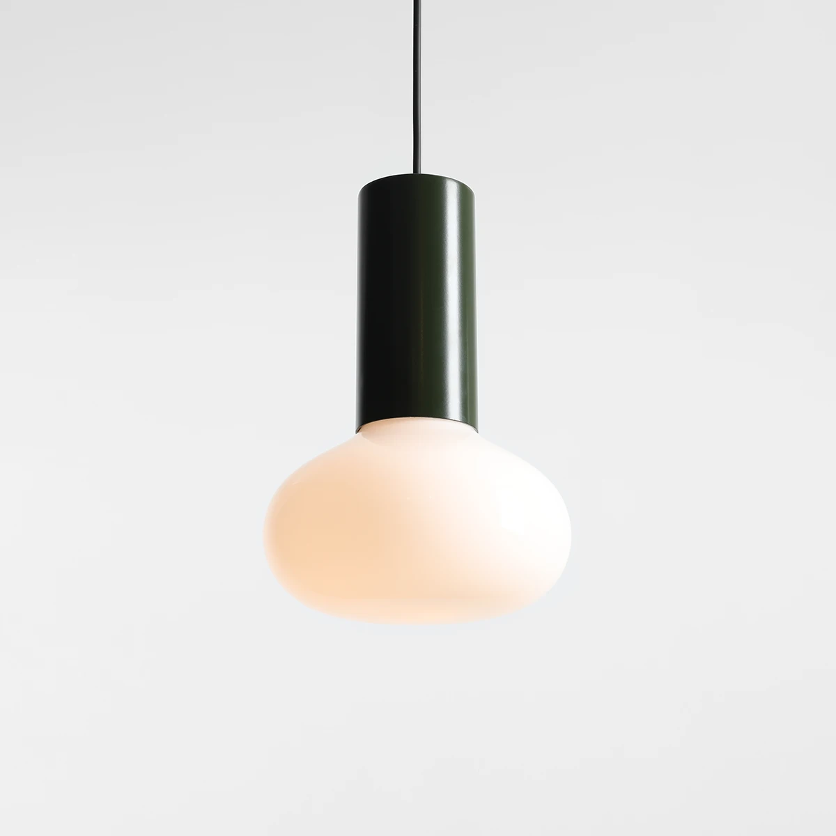Lampa wisząca Flo Moss D19 z zielonym metalowym kloszem i mlecznym, okrągłym szkłem. Kąt ujęcia z góry, produkt zwisający na cienkim kablu, na jednolitym jasnym tle. Idealna do nowoczesnych wnętrz.