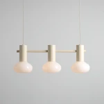 Lampa wisząca Flo Cream z trzema kloszami E14 w kształcie kulistym, wykonana z mlecznego szkła. Utrzymana w jasnej, kremowej kolorystyce, zawieszona na prostym metalowym stelażu. Produkt prezentowany na jednolitym tle.