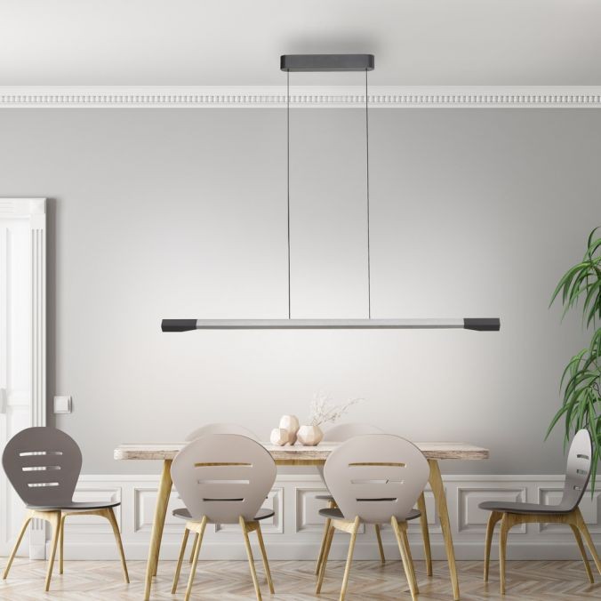 Lampa wisząca LED Hoop 27W 3000K wykonana z aluminium i antracytu, zawieszona na cienkich żyłkach. Ma prostokątny kształt z matowym wykończeniem, umieszczona nad drewnianym stołem w jasnym wnętrzu z szarymi krzesłami.