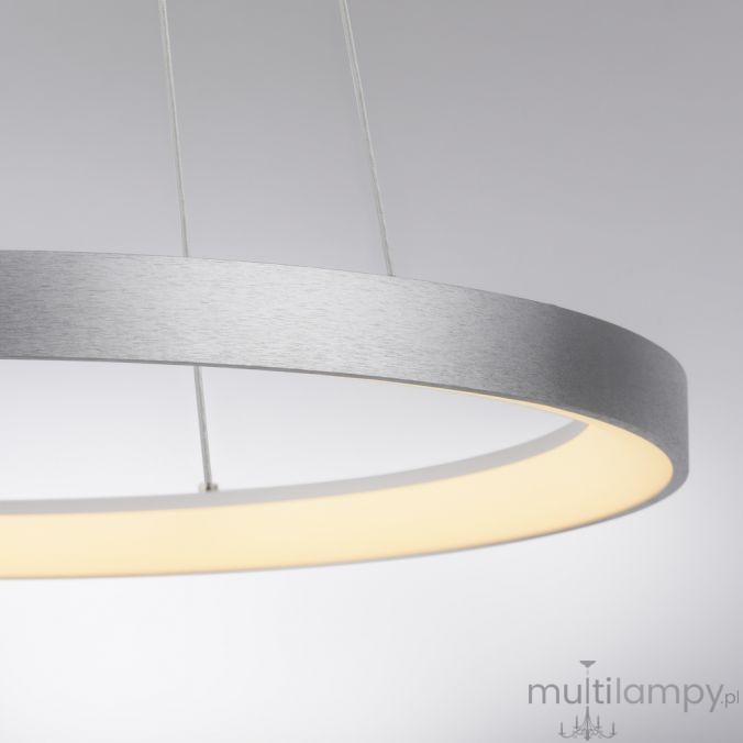 Lampa wisząca LED Hoop w kształcie koła, o mocy 37W i barwie światła 3000K. Posiada aluminiowy, matowy klosz z białym, emitującym światło obrzeżem. Zawieszona na cienkich linkach, widoczna z boku, na jednolitym tle.