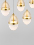 Lampa wisząca Arena 5xLED 58W w kolorze czarnym i złotym, z pięcioma okrągłymi kloszami z transparentnego szkła i białym matowym wykończeniem, zawieszona na cienkich linkach. Ujęcie z przodu, na jednolitym tle.