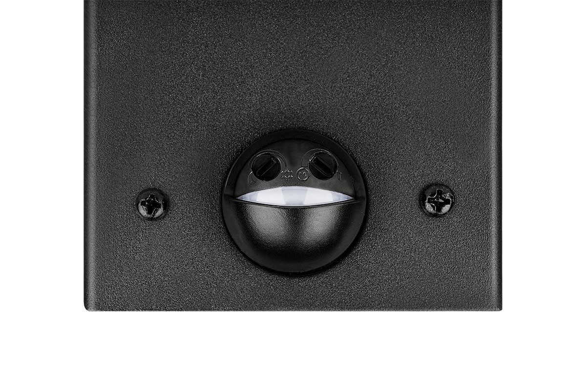 Czarny kinkiet zewnętrzny Denver z czujnikiem ruchu, wykonany z materiału o matowej fakturze. Widoczne elementy to okrągły czujnik oraz dwa otwory na śruby montażowe. Produkt pokazany z przodu, na jednolitym tle.