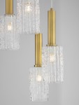 Lampa wisząca Oroya z pięcioma kloszami E27 w kolorze czarnym i złotym. Klosze z przezroczystego szkła o teksturowanej powierzchni, zamocowane na złotych rurkach. Ujęcie z boku, podkreślające detal i elegancki design.