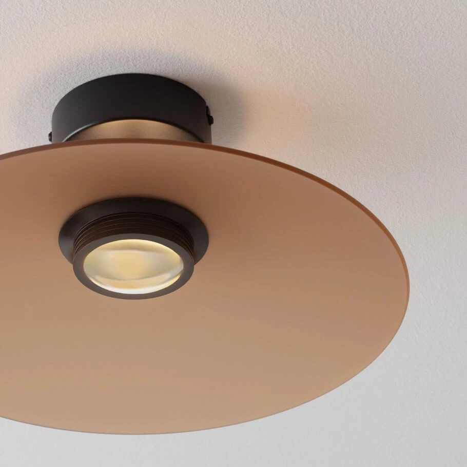 Lampa sufitowa Peca z czarnym mocowaniem i brązowym kloszem, z jednym źródłem światła LED 12W. Widok z dołu, ukazujący okrągły, płaski klosz oraz centralnie umieszczoną oprawę. Tło białe, minimalistyczne.