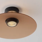 Lampa sufitowa Peca z czarnym mocowaniem i brązowym kloszem, z jednym źródłem światła LED 12W. Widok z dołu, ukazujący okrągły, płaski klosz oraz centralnie umieszczoną oprawę. Tło białe, minimalistyczne.