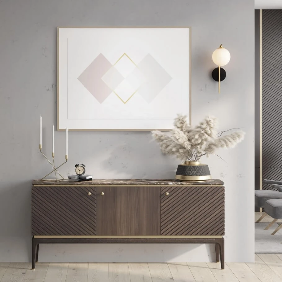 Kinkiet Chao 1xG9 w kolorze czarnym i złotym, montowany na ścianie. Okrągły klosz z białego szkła, umieszczony na czarnej podstawie. W tle minimalistyczna aranżacja wnętrza z komodą i dekoracjami.