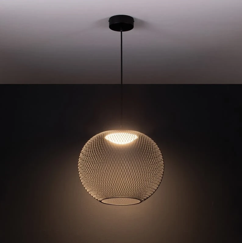 Czarna lampa wisząca Rita z siatkowym kloszem, źródło światła LED 19W, zawieszona na cienkim przewodzie. Klosz ma okrągły kształt, emitując ciepłe światło. Tło w ciemnym kolorze, podkreślające nowoczesny design.